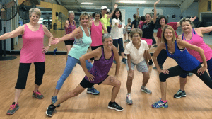 Zumba at Vermont Sport & Fitness club. 8 women posing after a great class at the gym
