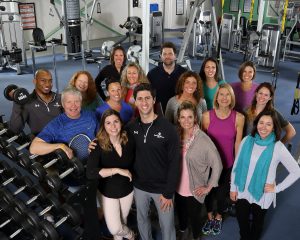 Group photo of all of the staff at Vermont Sport & Fitness club. This photo was taking in the weight room centeraly located in the gym.